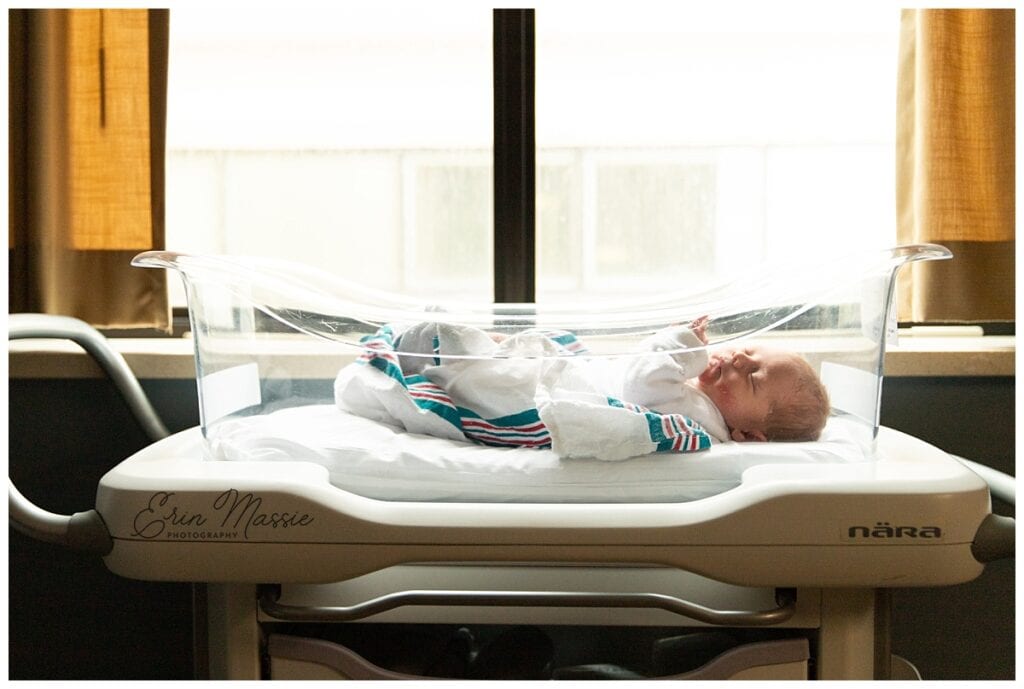 backlit newborn baby boy in bassinette in front of hospital window