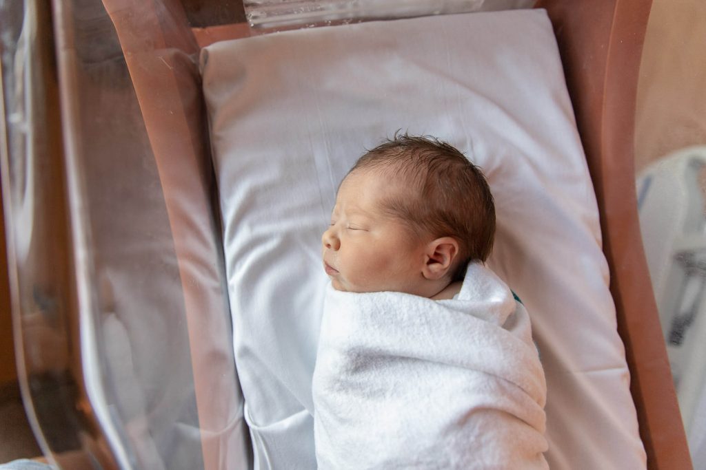 newborn baby girl in bassinet at hospital