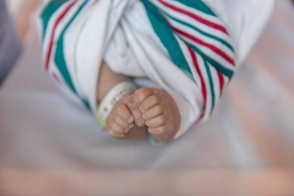 newborn baby feet wrapped in hospital blanket