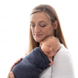 white high key photo of mom holding baby boy on sholder