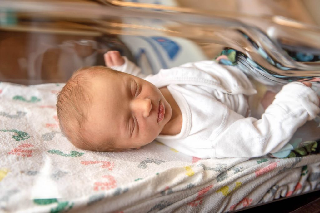newborn girl sleeping in hospital bassinet