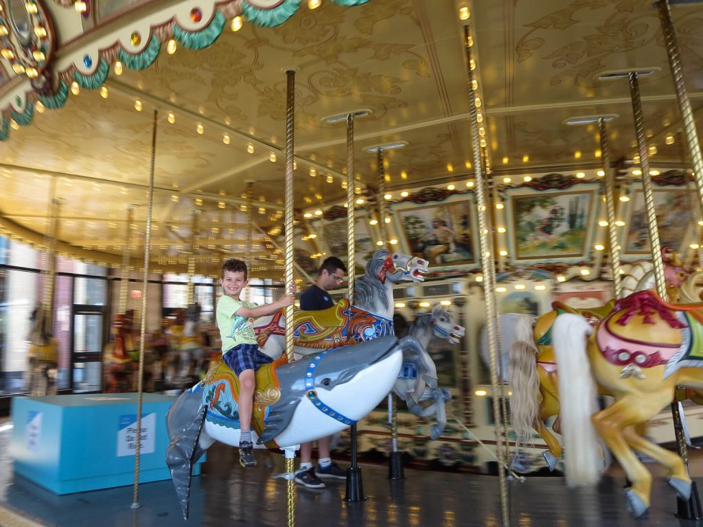 young boy spinning on a carousel at the Grand Rapids Public Museum