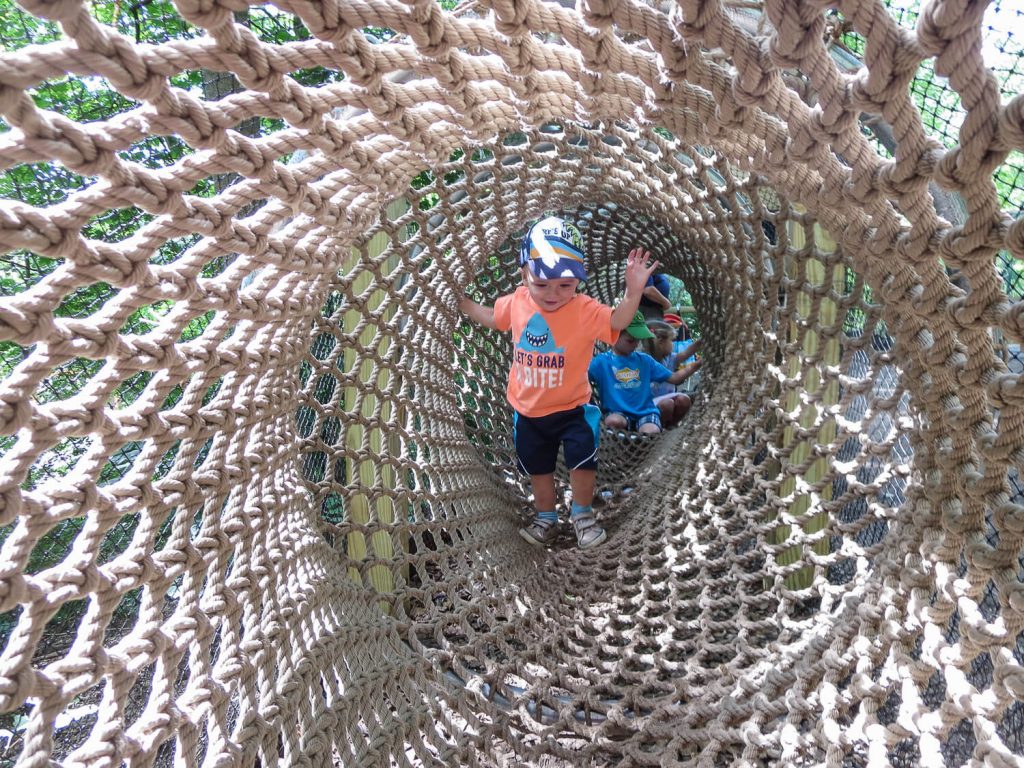 toddler boy walking through a rope tunnel at John Ball Zoo