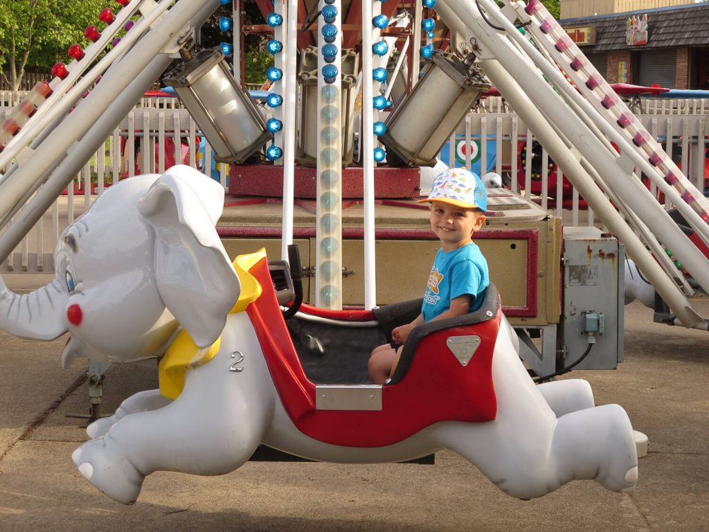 toddler boy sitting in an elephant ride at Michigan's Adventure