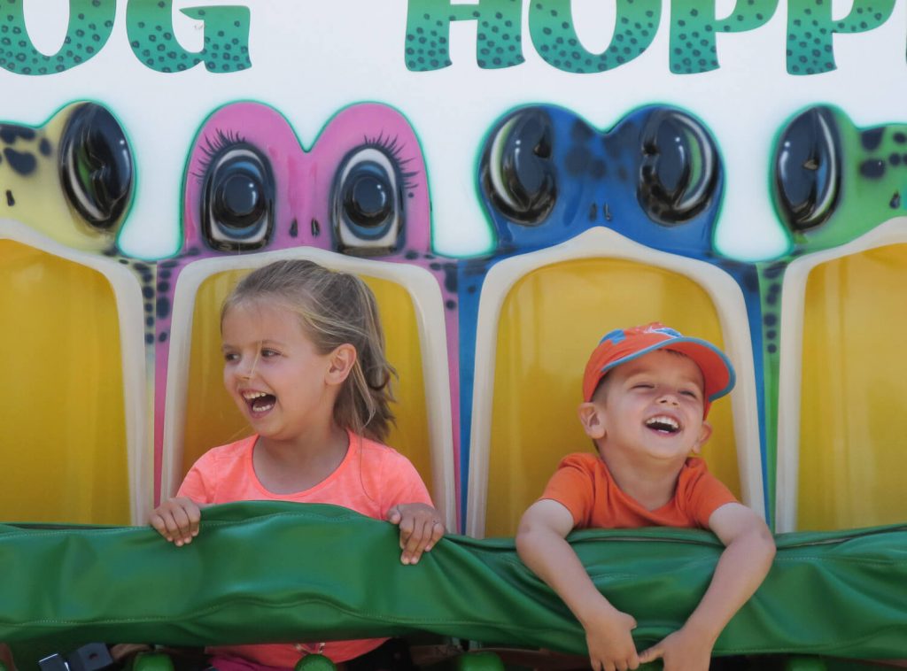 young girl and boy laughing on Frog Hopper ride at Michigan's Adventure
