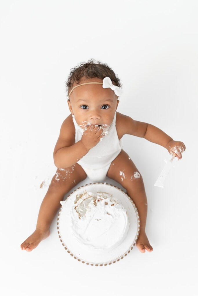 birds eye view of baby girl eating smashed cake